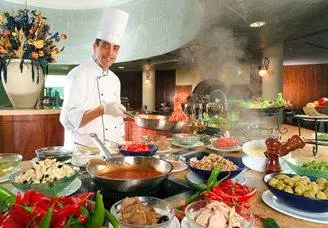 Chef preparing food at a live cooking station for a Sunrise Café & Bistro catered event